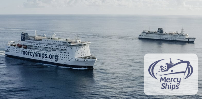 De hospitaalschepen van Mercy Ships op zee, met het Mercy Ships logo in de hoek.