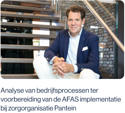 Arjan de Rooy zit op een trap en kijkt lachend naar een analyse.